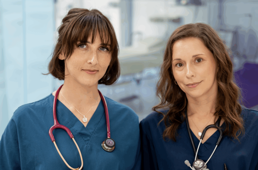 Screenshot 2025-07-04 at 20.32.02 Co-founders of Surviving in Scrubs Dr Chelcie Jewitt and Dr Becky Cox are wearing scrubs with stethoscopes round their necks looking seriously at the camera